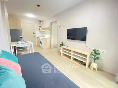 Modern living room with open kitchen, featuring sleek furniture and a wall-mounted TV.