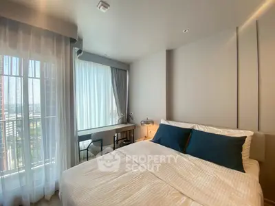 Modern bedroom with large window and stylish decor in a high-rise apartment.