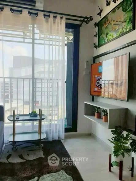 Modern living room with balcony view, stylish decor, and wall-mounted TV in urban apartment.