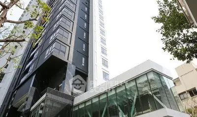 Modern high-rise building with sleek glass facade and contemporary design.