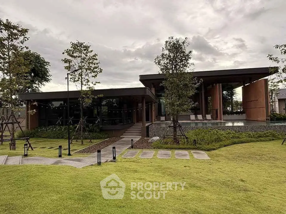 Modern architectural home with lush green lawn and sleek design.