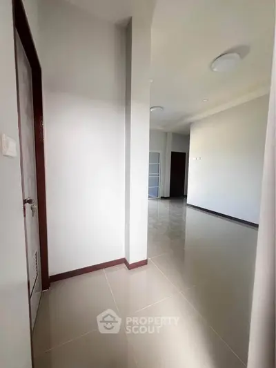 Spacious modern hallway with sleek tile flooring and minimalist design.