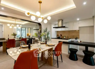 Luxurious modern dining area with elegant lighting and open kitchen layout.
