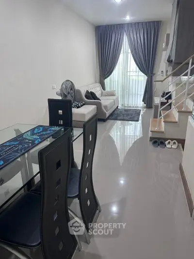 Modern living room with sleek dining area and stylish staircase