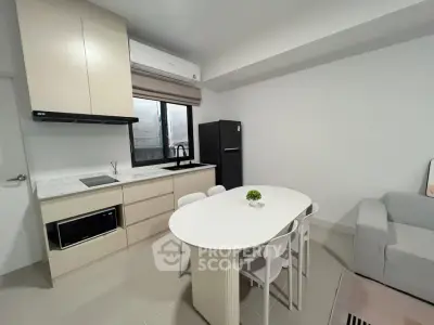 Modern open-layout kitchen with dining area and cozy living space in a stylish apartment.