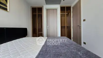 Modern bedroom with sleek design and ample closet space in a contemporary apartment.