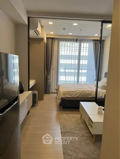 Modern bedroom with large windows and stylish decor in a high-rise apartment.