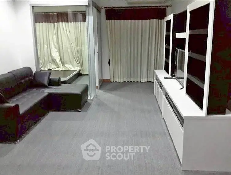 Spacious living room with modern black sofa and sleek entertainment unit