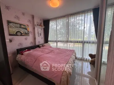 Cozy bedroom with large windows and pink bedding in a modern apartment