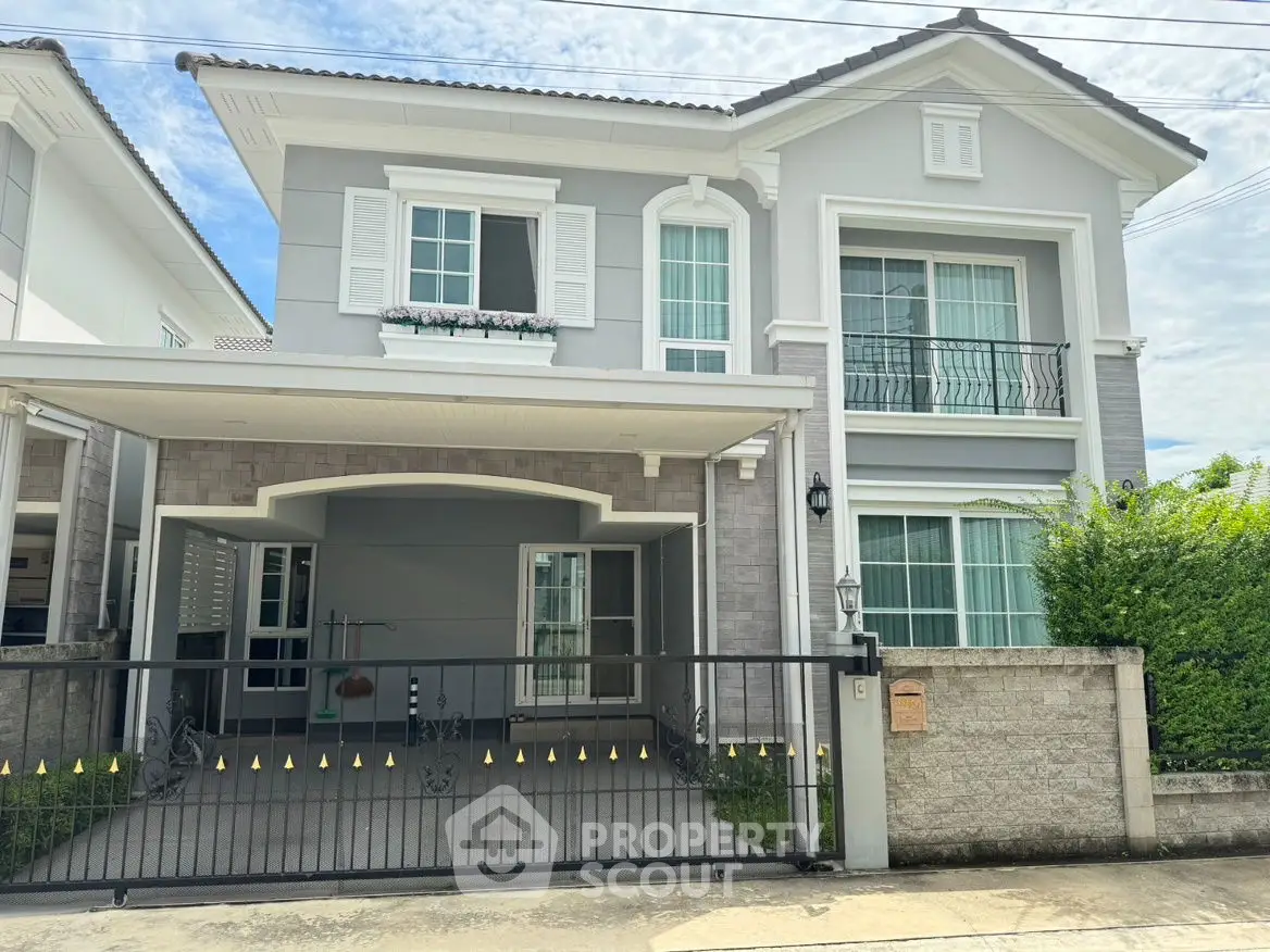 Elegant two-story house with modern facade and gated driveway in suburban neighborhood.
