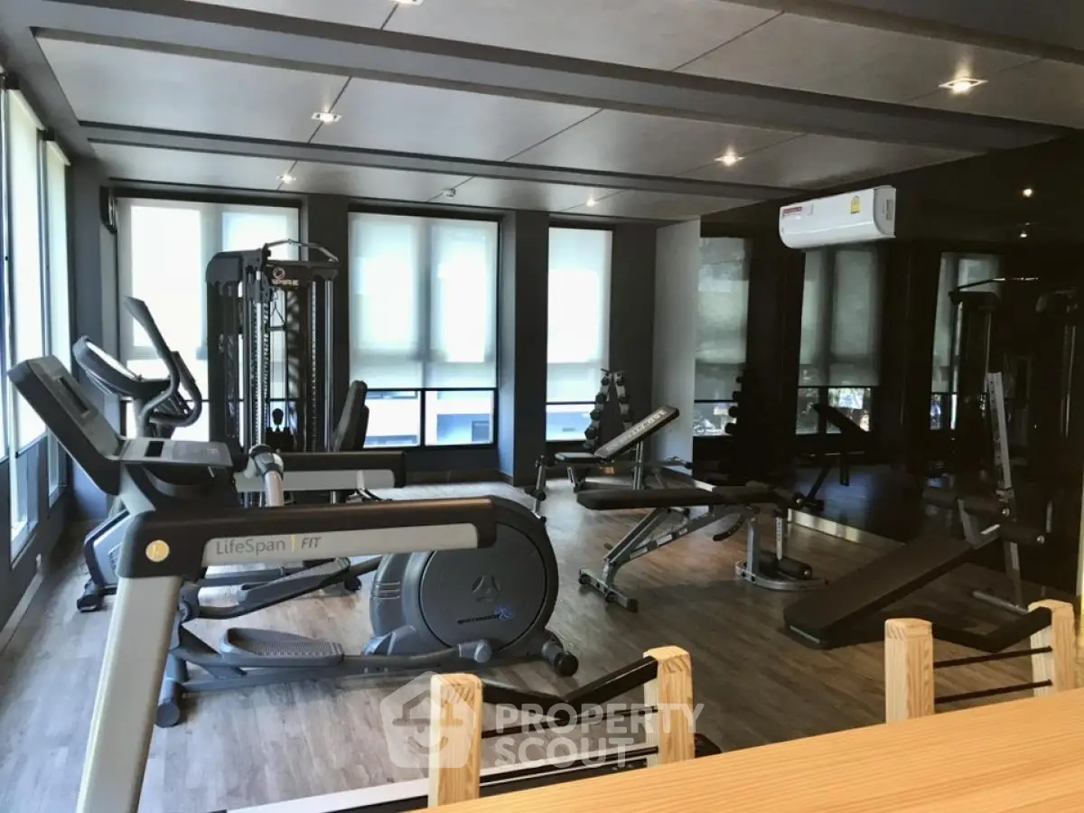 Modern gym with state-of-the-art fitness equipment and large windows for natural light.