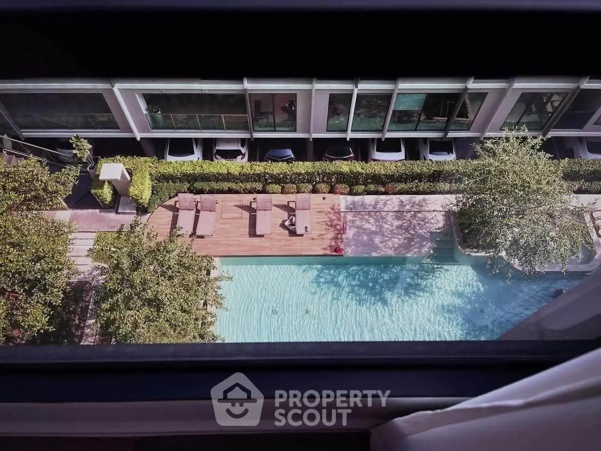 Stunning aerial view of modern apartment complex with inviting swimming pool and lush greenery.