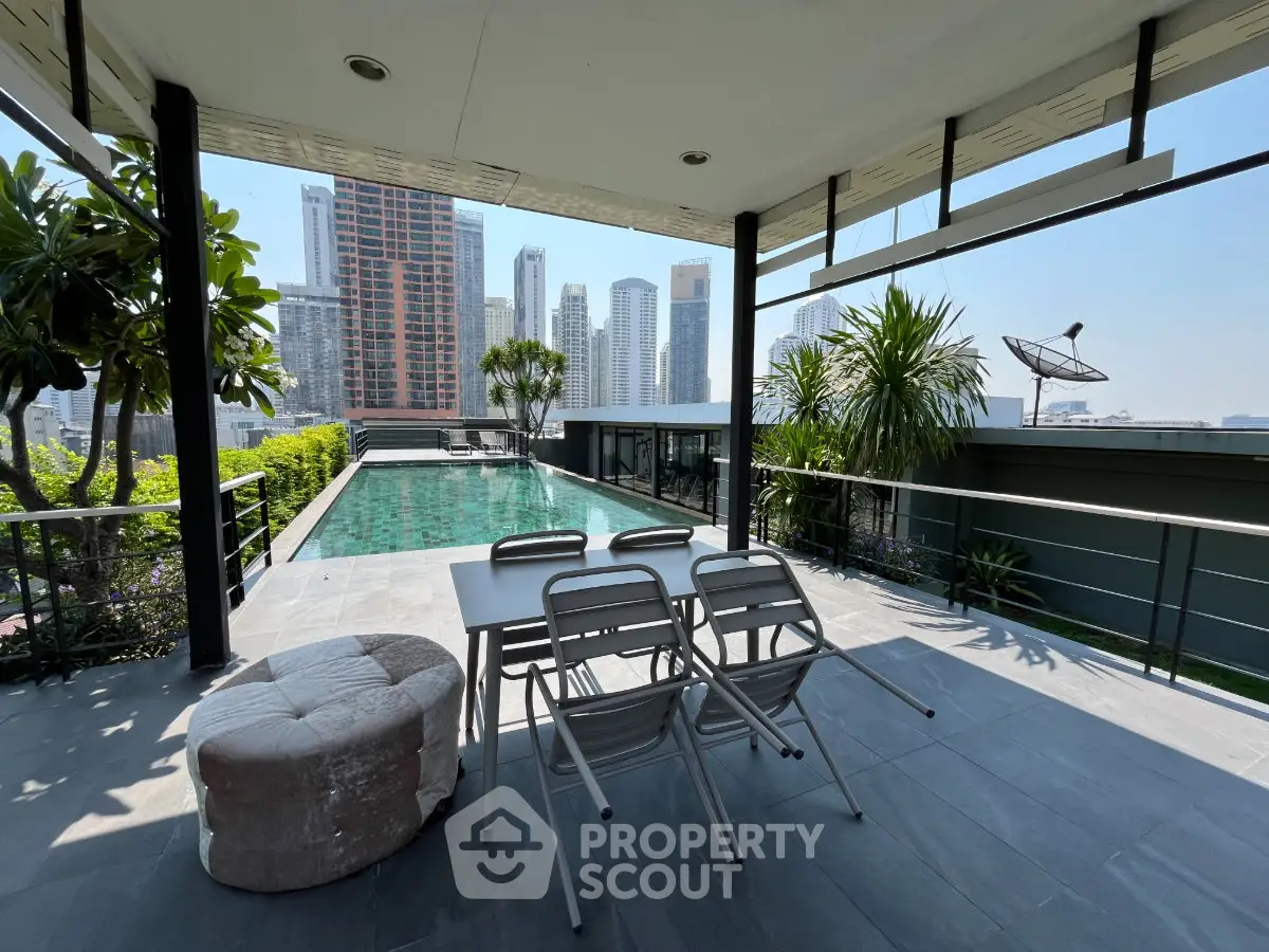 Stunning rooftop pool with city skyline views and modern outdoor seating area.