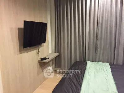 Modern bedroom with wall-mounted TV and stylish curtains