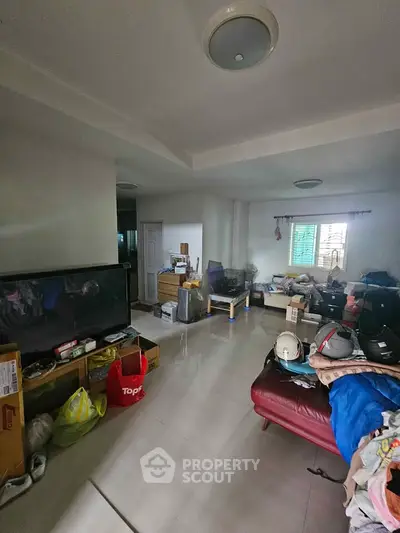 Spacious living room with modern decor and ample natural light, perfect for family gatherings.