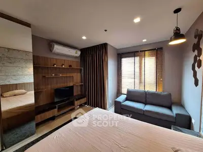 Modern bedroom with stylish decor, featuring a cozy bed, sleek TV unit, and comfortable sofa under natural light.