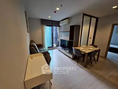 Modern living room with dining area and balcony access in a stylish apartment.