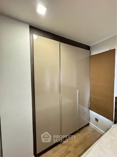 Modern bedroom with sleek built-in wardrobe and wooden flooring