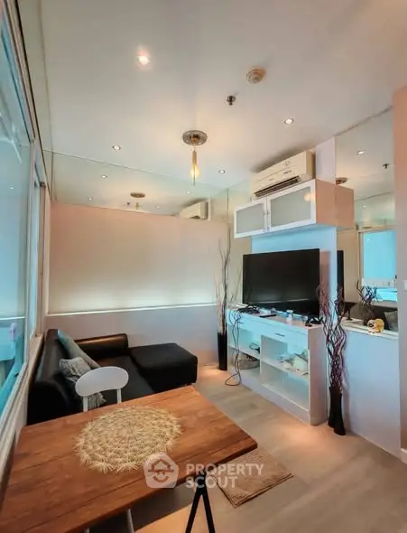 Modern living room with stylish decor and large TV, featuring cozy seating and elegant lighting.