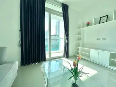 Bright modern living room with large window and sleek furniture, offering a serene city view.