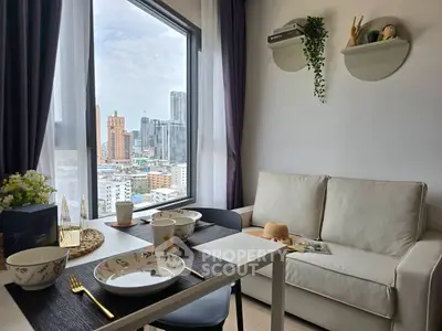Modern living room with city view, cozy sofa, and elegant dining setup in urban apartment.