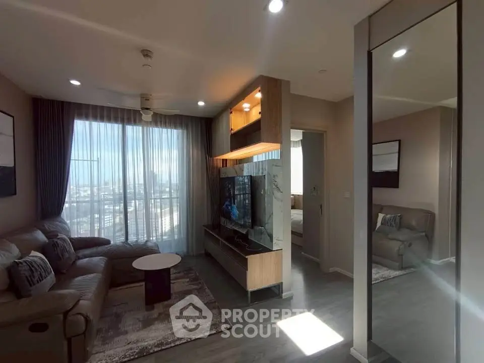 Modern living room with large windows and stylish furniture in a high-rise apartment.