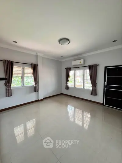 Spacious unfurnished living room with large windows and air conditioning
