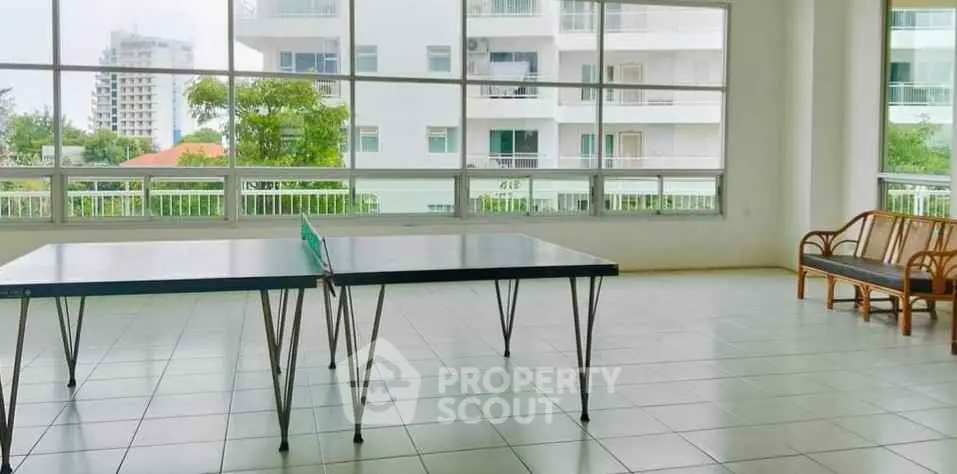Spacious recreational area with table tennis and seating, offering a bright and airy ambiance.