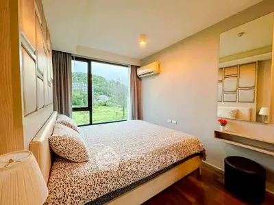 Cozy bedroom with scenic view, modern decor, and ample natural light.