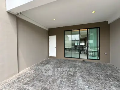 Modern patio with sliding glass doors leading to a stylish interior, perfect for seamless indoor-outdoor living.