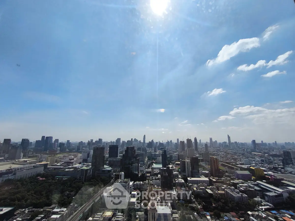 Stunning cityscape view from a high-rise building showcasing urban skyline under a bright blue sky.