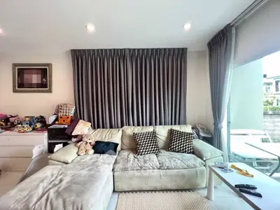Spacious living room with plush sofa and large windows for natural light