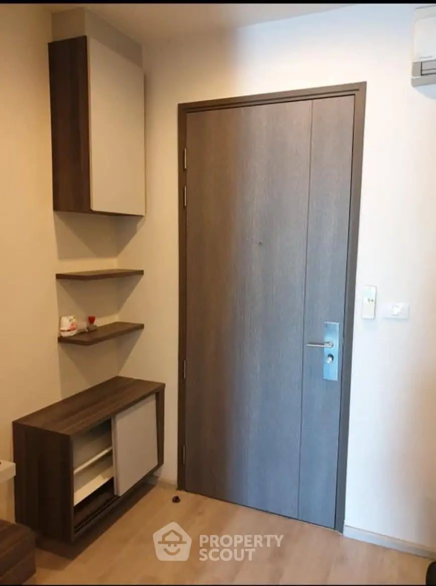 Modern apartment entrance with sleek wooden door and stylish storage units.