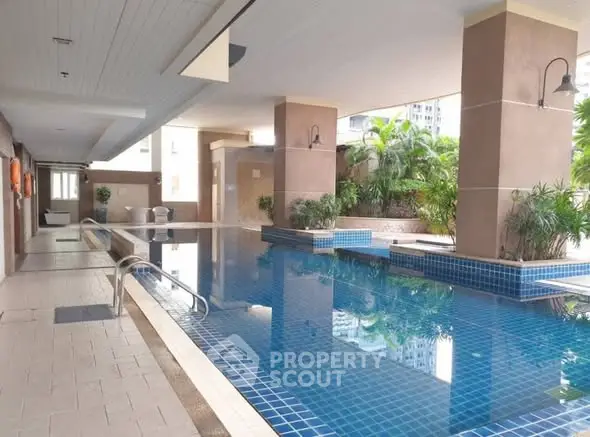 Luxurious indoor pool area with modern design and lush greenery, perfect for relaxation and leisure.