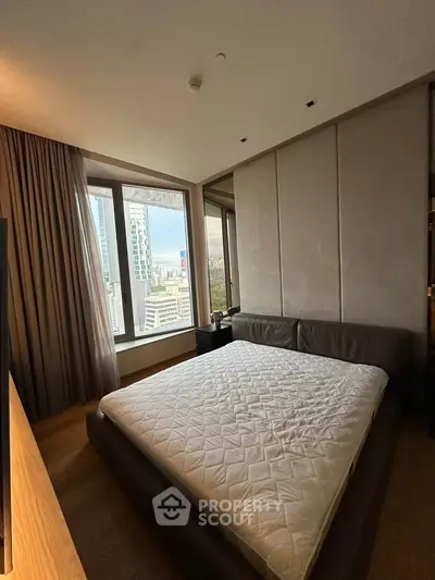 Luxurious bedroom with stunning city view and modern decor in high-rise apartment.