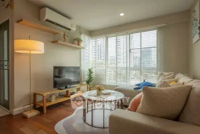 Cozy living room with modern decor and large windows offering natural light.
