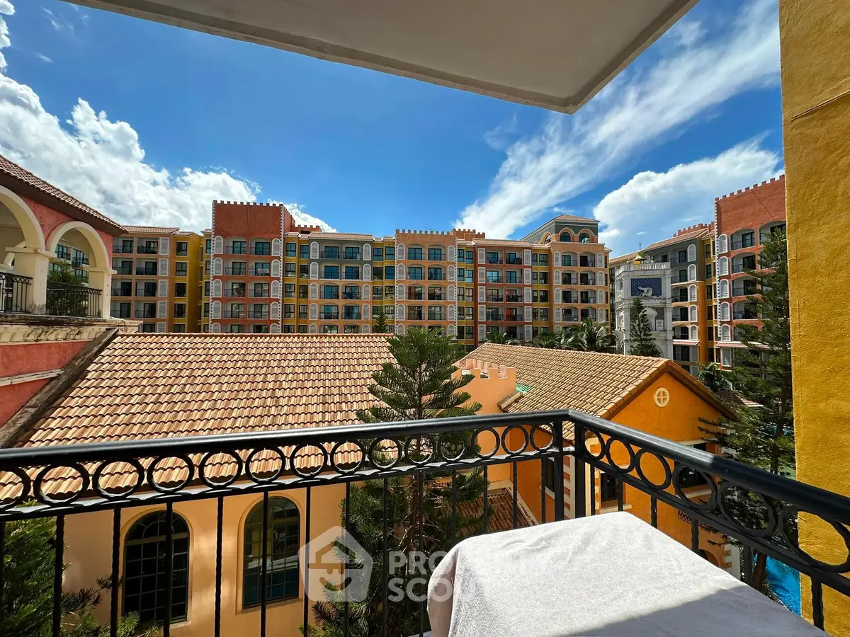 Stunning view from a balcony overlooking a vibrant, colorful apartment complex with clear blue skies.