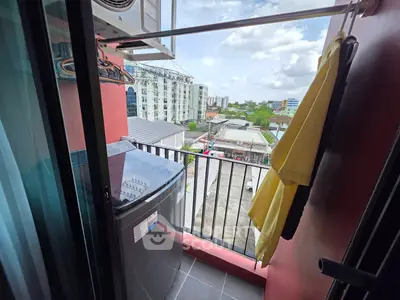Charming balcony with washing machine and city view, perfect for urban living convenience.