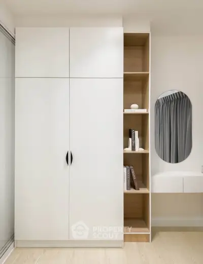 Modern minimalist wardrobe with built-in shelves and mirror in stylish bedroom.