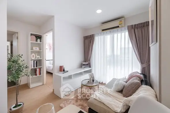 Modern living room with cozy sofa, air conditioning, and natural light from large window.