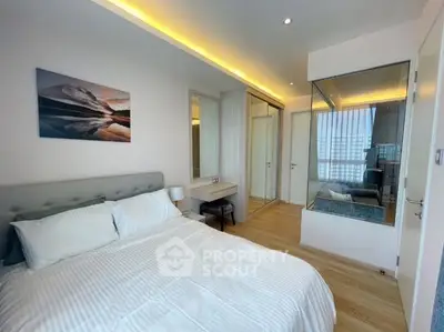 Modern bedroom with elegant lighting and mirrored wardrobe in a stylish apartment.
