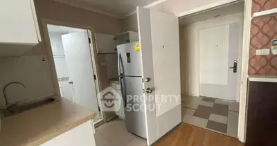 Compact kitchen with fridge and sink in modern apartment