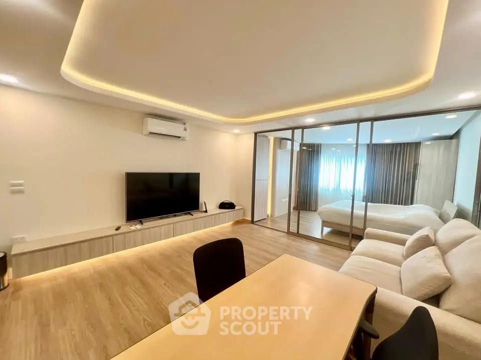 Modern open-plan living room with sleek design and cozy bedroom view