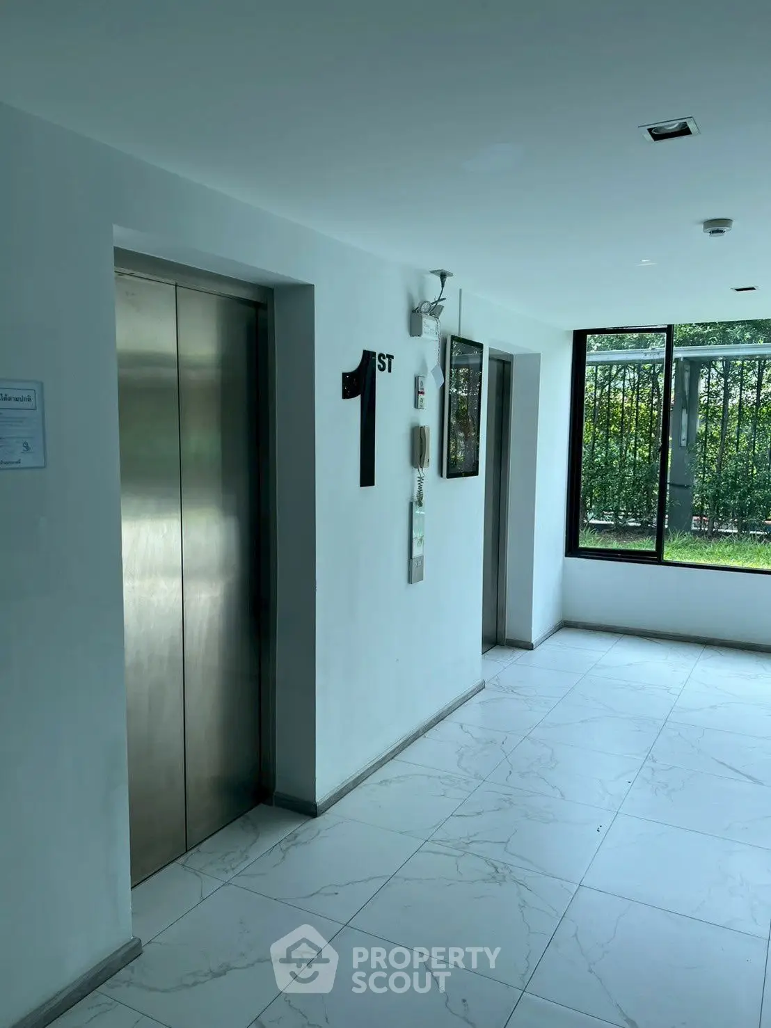 Modern building elevator lobby with natural light and garden view