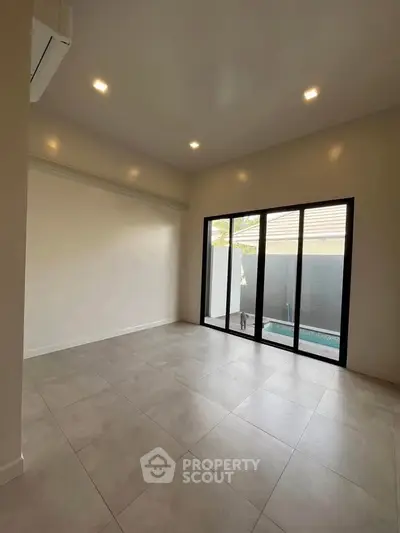 Spacious modern room with large windows and pool view