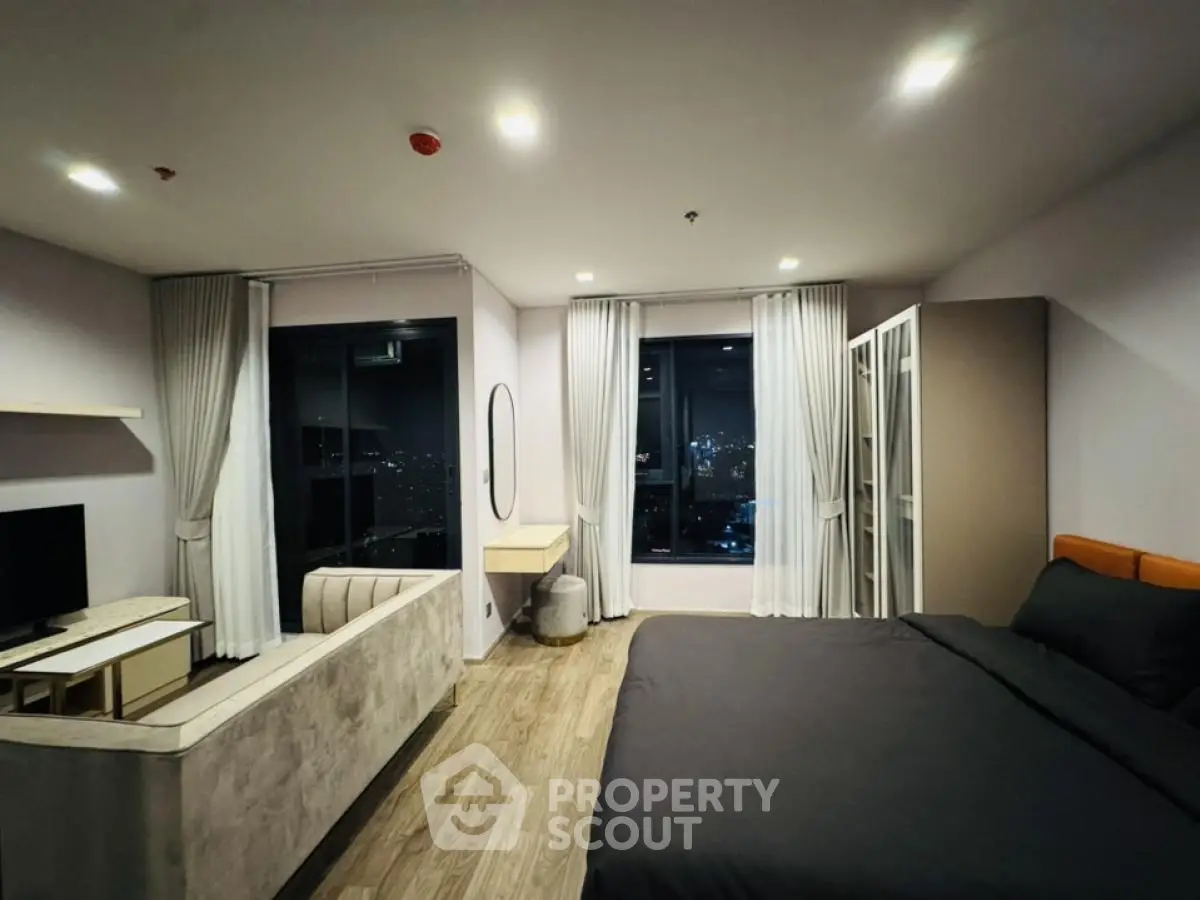Modern bedroom with city view, featuring sleek design and cozy ambiance.