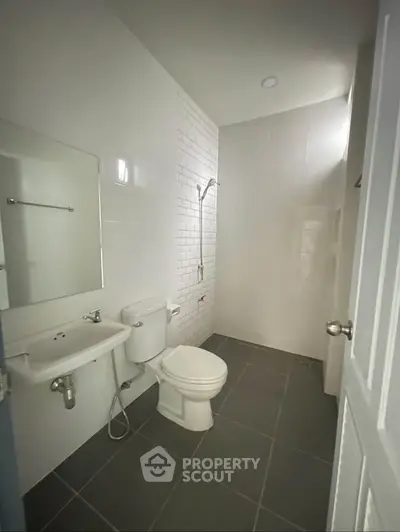 Modern minimalist bathroom with sleek fixtures and white subway tiles.