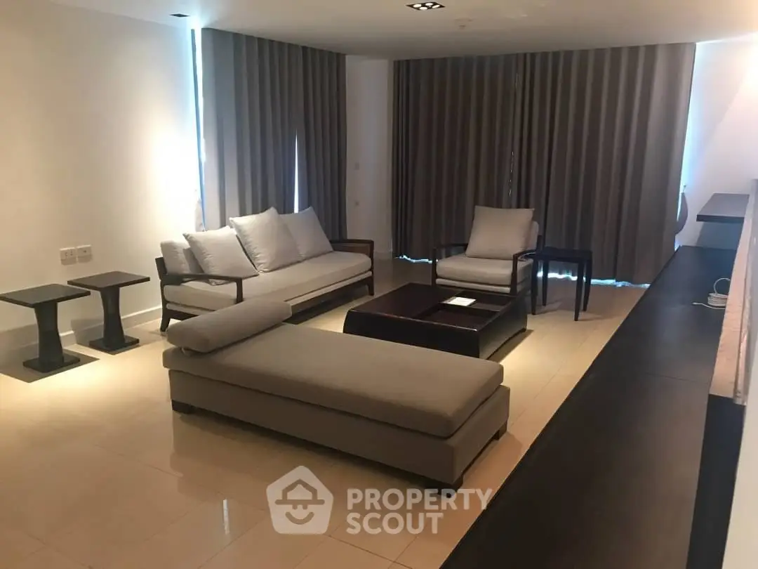 Spacious modern living room with elegant furniture and natural lighting.