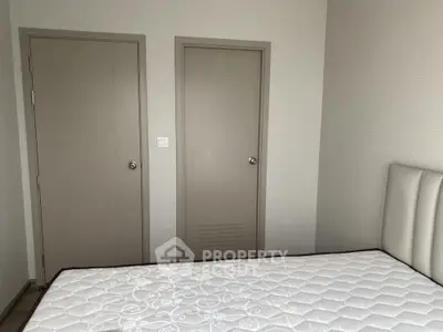 Minimalist bedroom with neutral tones and a comfortable mattress.