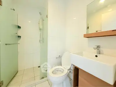 Modern bathroom with glass shower and sleek white fixtures